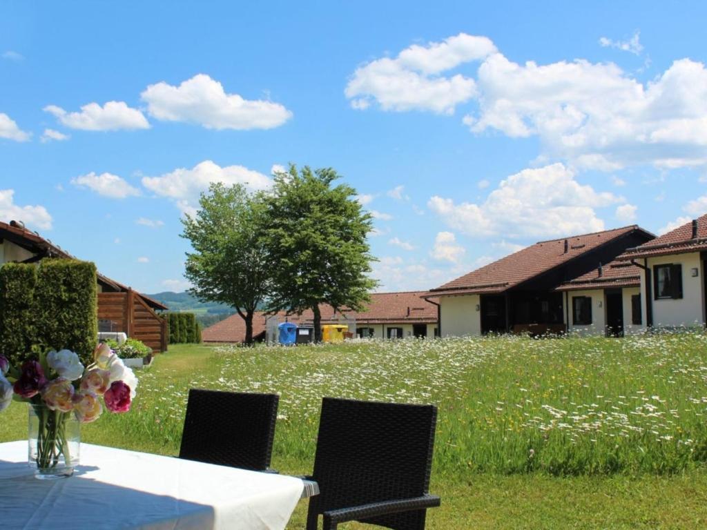 una mesa con un jarrón de flores en la parte superior de un campo en Ferienhaus Nr 56, Kategorie Komfort, Feriendorf Hochbergle, Allgäu, en Bichel