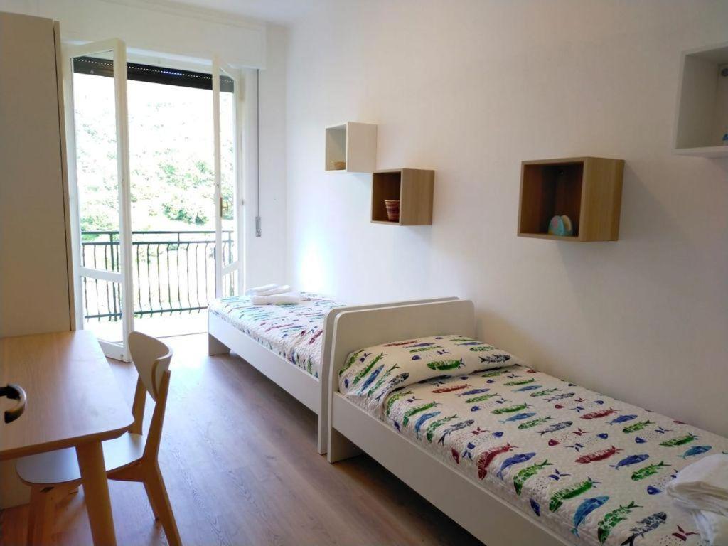 1 dormitorio con cama, mesa y ventana en Villa Maremonti - con 3 piscine, en Sestri Levante