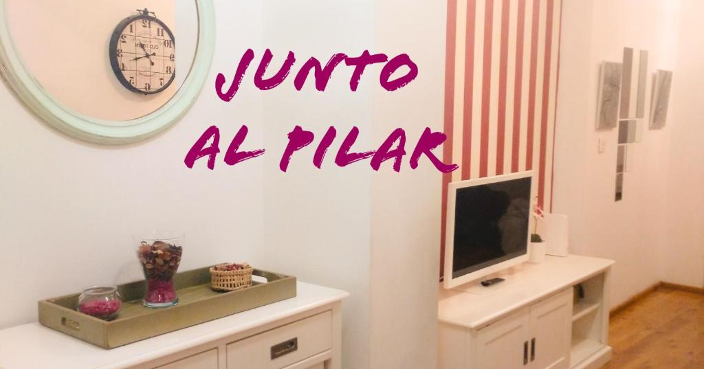 a room with a tv and a mirror on the wall at JUNTO AL PILAR in Zaragoza