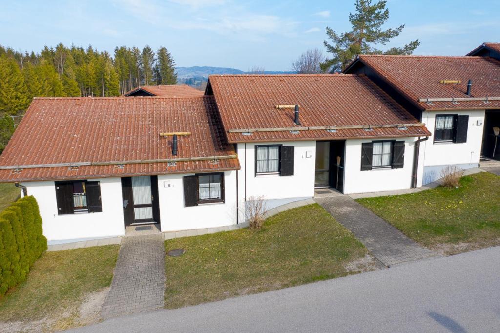 uma vista aérea de uma casa branca com um telhado vermelho em Ferienhaus Nr 27, Kategorie Premium, Feriendorf Hochbergle, Allgäu em Bichel