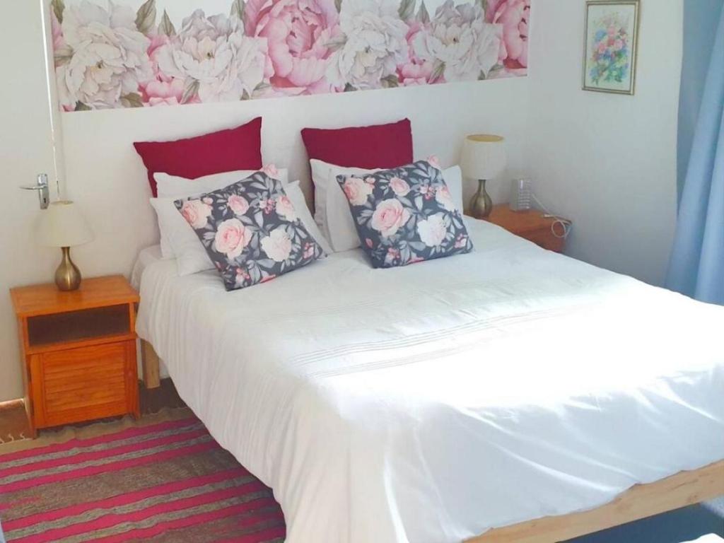 um quarto com uma cama com duas almofadas em The Little Cottages em Howick