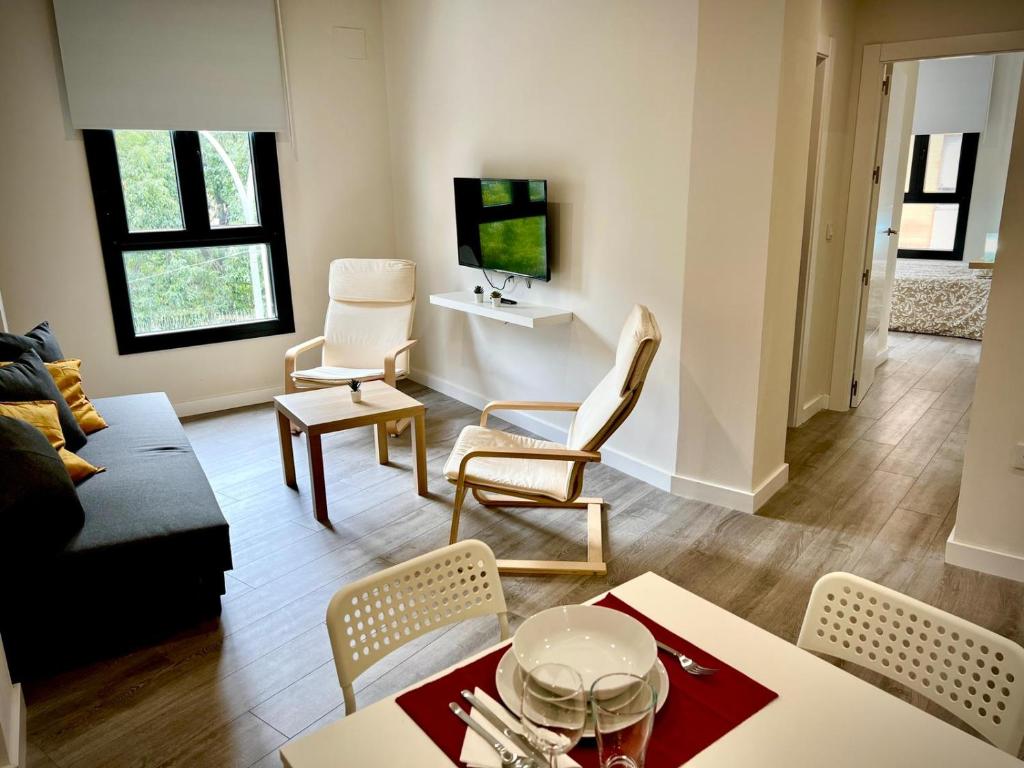 een woonkamer met een bank en een tafel en stoelen bij Apartamento Dama de noche in Córdoba
