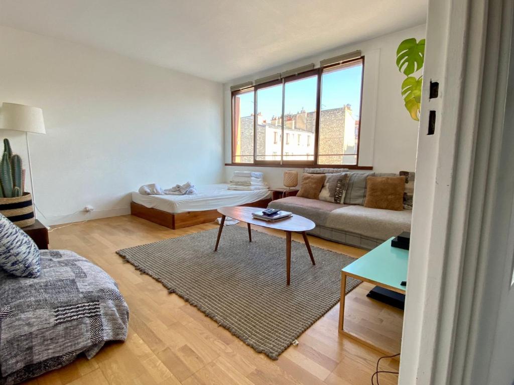 un salon avec un canapé et une table dans l'établissement Home Sweet Home Parmentier, à Paris