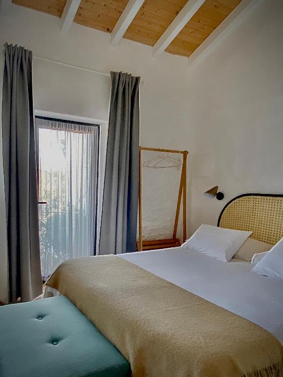 a bedroom with a large bed and a window at Casa no Montinho in Ourique