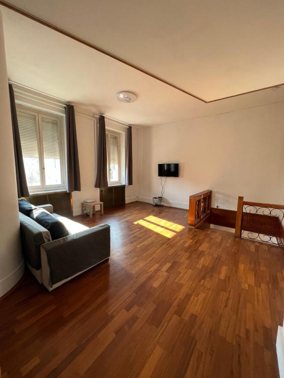 een lege woonkamer met een bank en een televisie bij L’ÉMERAUDE 2 in Châlons-en-Champagne