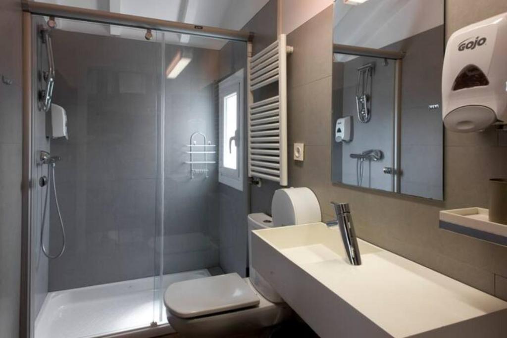 a bathroom with a shower and a sink and a toilet at Pensión Iturriza in Donostia-San Sebastián