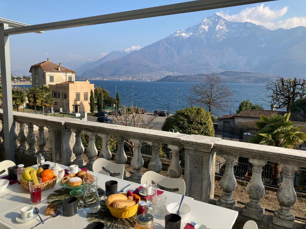 a table with food on a balcony with a view of the ocean at Residence Il Bosso in Domaso