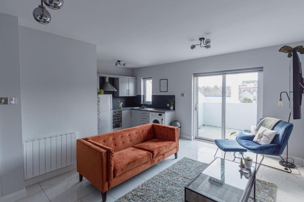 Causeway Coast Sea Front apartment - Ballycastle في باليكاسل: غرفة معيشة مع أريكة وكرسي