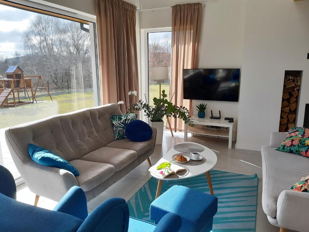 a living room with a couch and a table at VILLA RA with garden and sauna at the Baltic Sea in Kołczewo