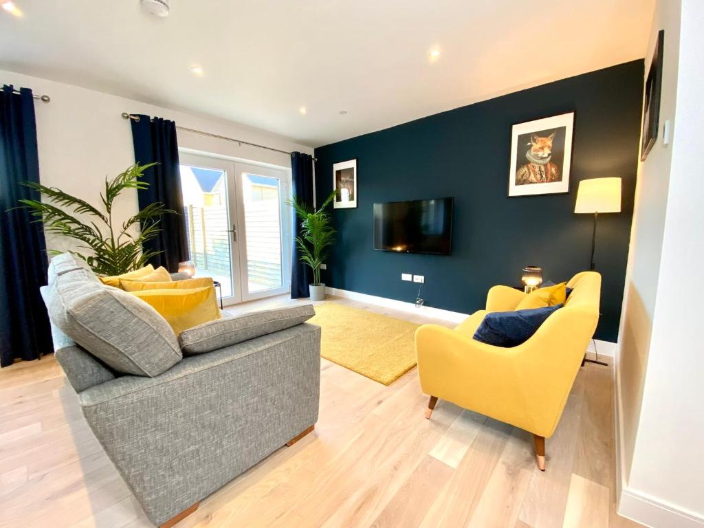 uma sala de estar com um sofá cinzento e cadeiras amarelas em Stunning NEW Large 3 bedroom House - 5 Minutes to the nearest Beach! - Great Location - Garden - Parking - Fast WiFi - Smart TV - Newly decorated - sleeps up to 7! Close to Poole & Bournemouth & Sandbanks em Lytchett Minster