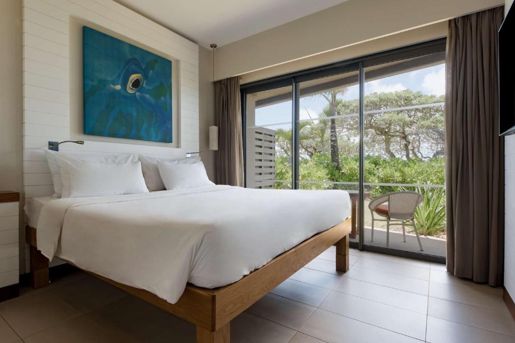 a bedroom with a large bed and a large window at Radisson Blu Poste Lafayette Resort & Spa (Adults Only) in Poste Lafayette