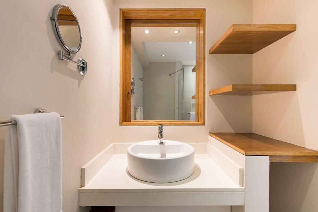 a bathroom with a sink and a mirror at Radisson Blu Poste Lafayette Resort & Spa (Adults Only) in Poste Lafayette