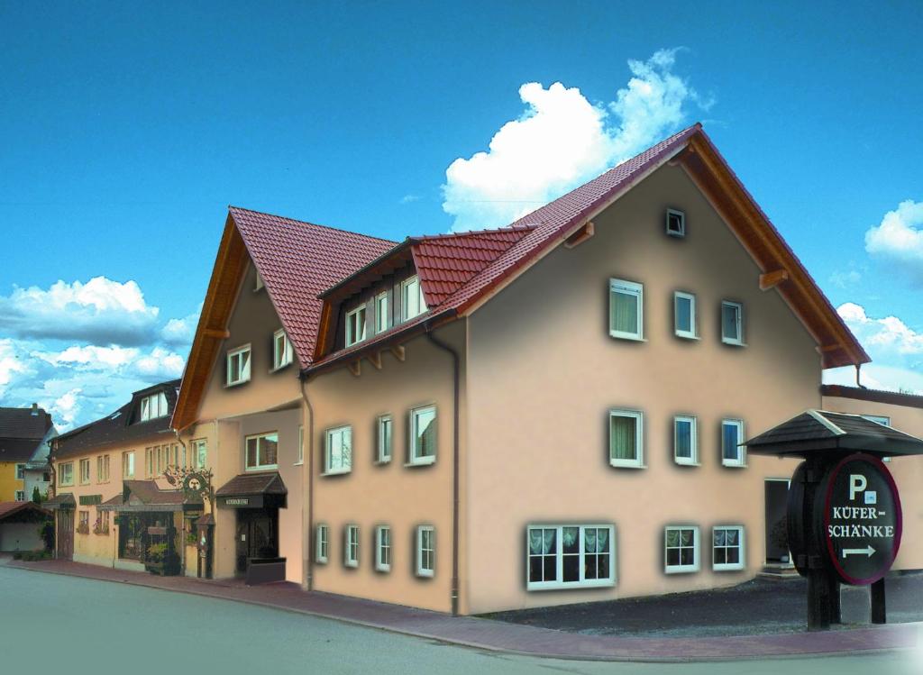 a large building with a red roof on a street at Hotel Küferschänke in Sinsheim