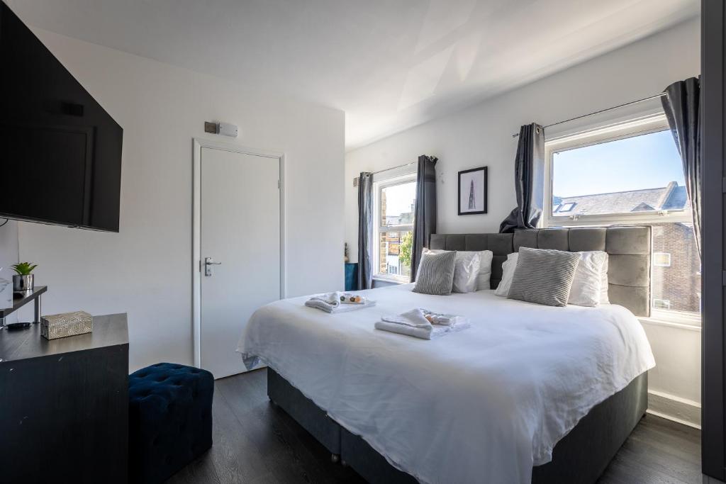 een slaapkamer met een groot wit bed en een raam bij The Finsbury Guesthouse in Londen