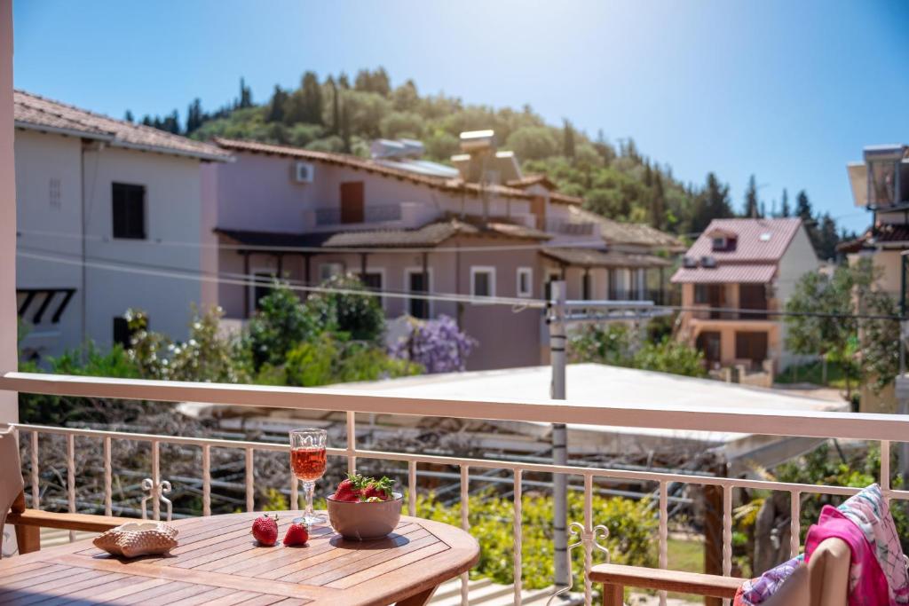 a table with a glass of wine on a balcony at Τrilogy Studios in Syvota