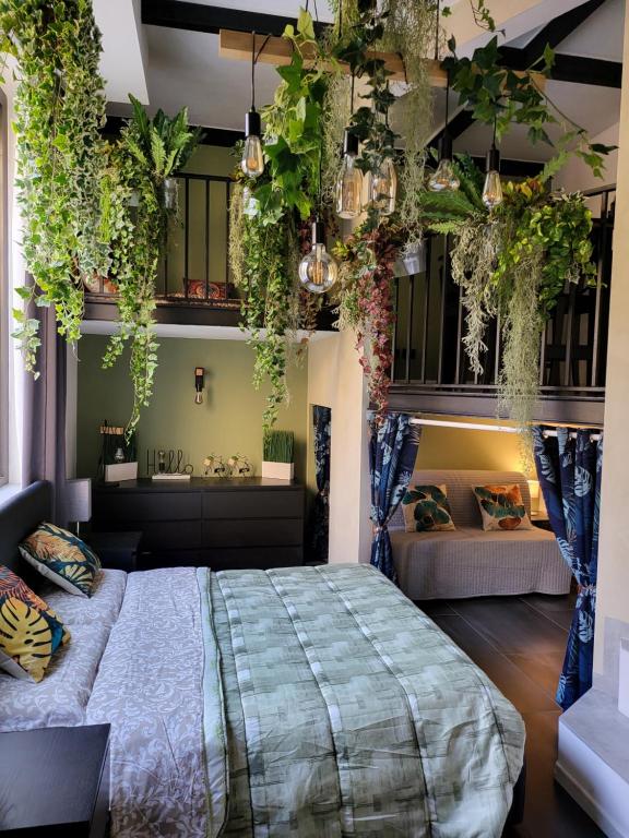 Un dormitorio con una cama con plantas colgando de los techos. en Dea Dreams APARTMENT Marghera WiFi Metro a 2 passi en Milán