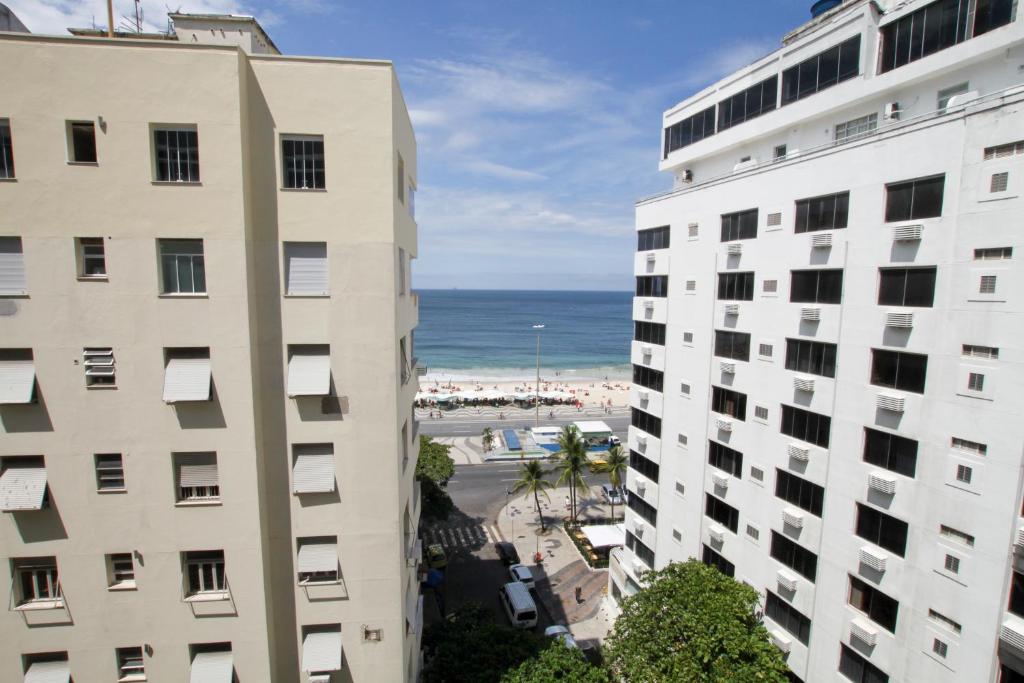 uma vista para a praia entre dois edifícios em Apartments Almirante Goncalves no Rio de Janeiro