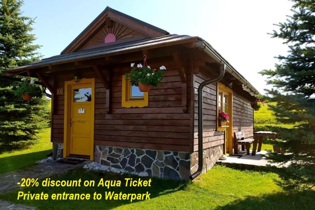 Cabaña de madera pequeña con puerta amarilla en Chatky 101 a 411 Tatralandia en Liptovský Mikuláš