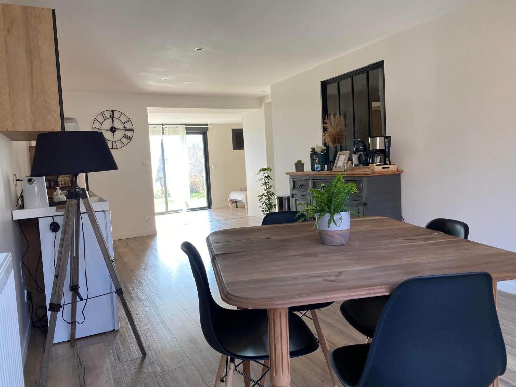 a dining room with a wooden table and chairs at Appartement tout confort et spacieux en campagne bourguignonne in Mancey