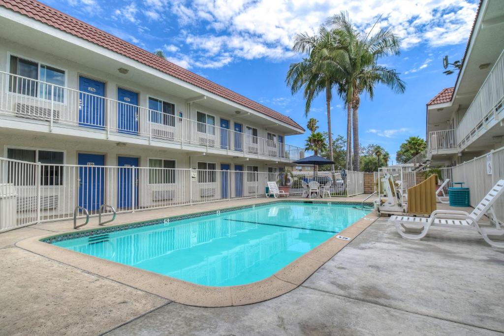 a swimming pool in front of a building with a resort at Motel 6-Costa Mesa, CA in Costa Mesa