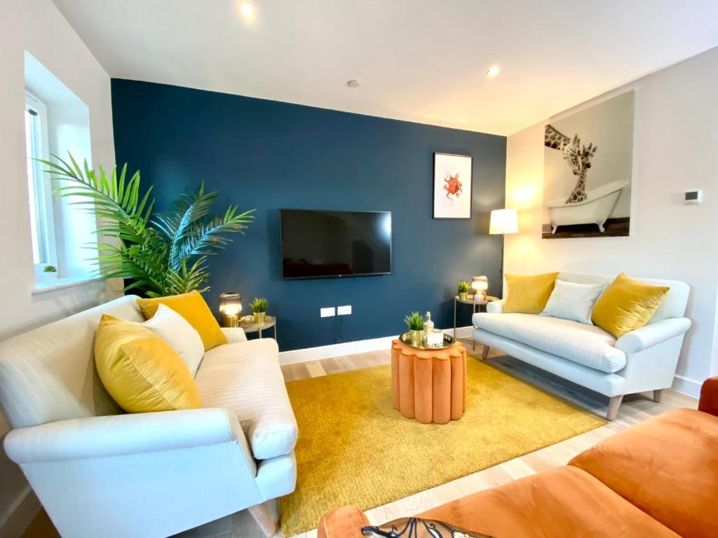 a living room with a couch and a tv at Amazing NEW Large 2 bedroom House - 5 Minutes to the nearest Beach! - Great Location - Garden - Parking - Fast WiFi - Smart TV - Newly decorated - sleeps up to 5! Close to Poole & Bournemouth & Sandbanks in Lytchett Minster