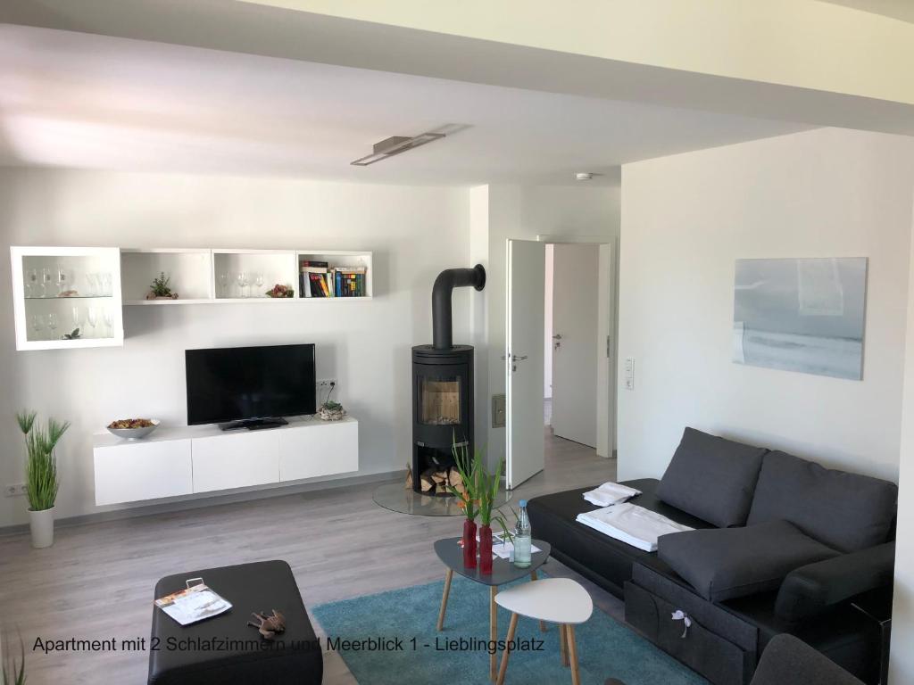 a living room with a black couch and a fireplace at Ferienhaus Strandläufer in Langballig