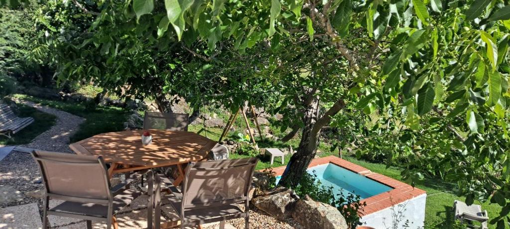 a table and chairs sitting under a tree at CASA DA VIZINHA, QUINTA DAS MEMÓRIAS in Santo António das Areias