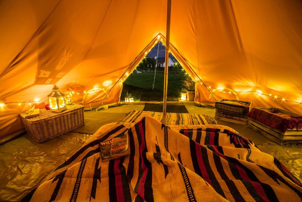 a tent with a bed in the middle of it at The Paddock Wildcamp in Perranporth