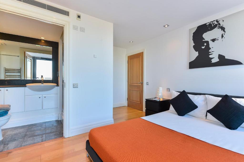a bedroom with a bed and a bathroom with a sink at Paddington Gardens in London