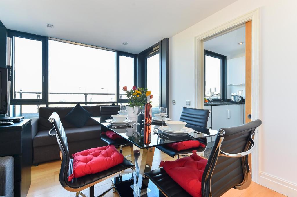 a dining room with a table and chairs with red pillows at Paddington Gardens in London