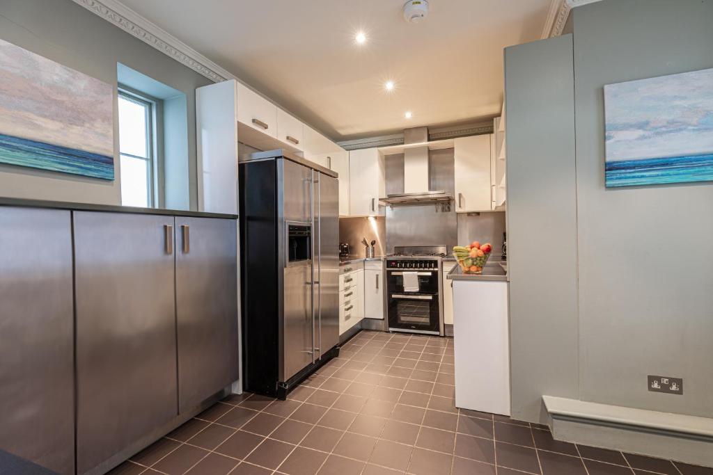 a kitchen with stainless steel appliances in a room at Paddington Gardens in London