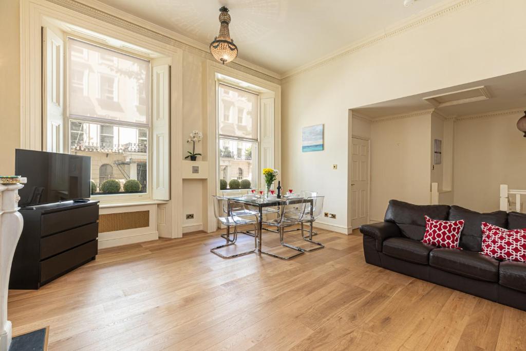 a living room with a couch and a table at Paddington Gardens in London