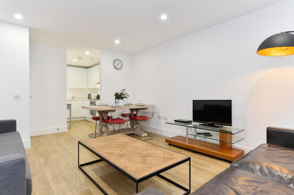 a living room with a couch and a table at Paddington Gardens in London