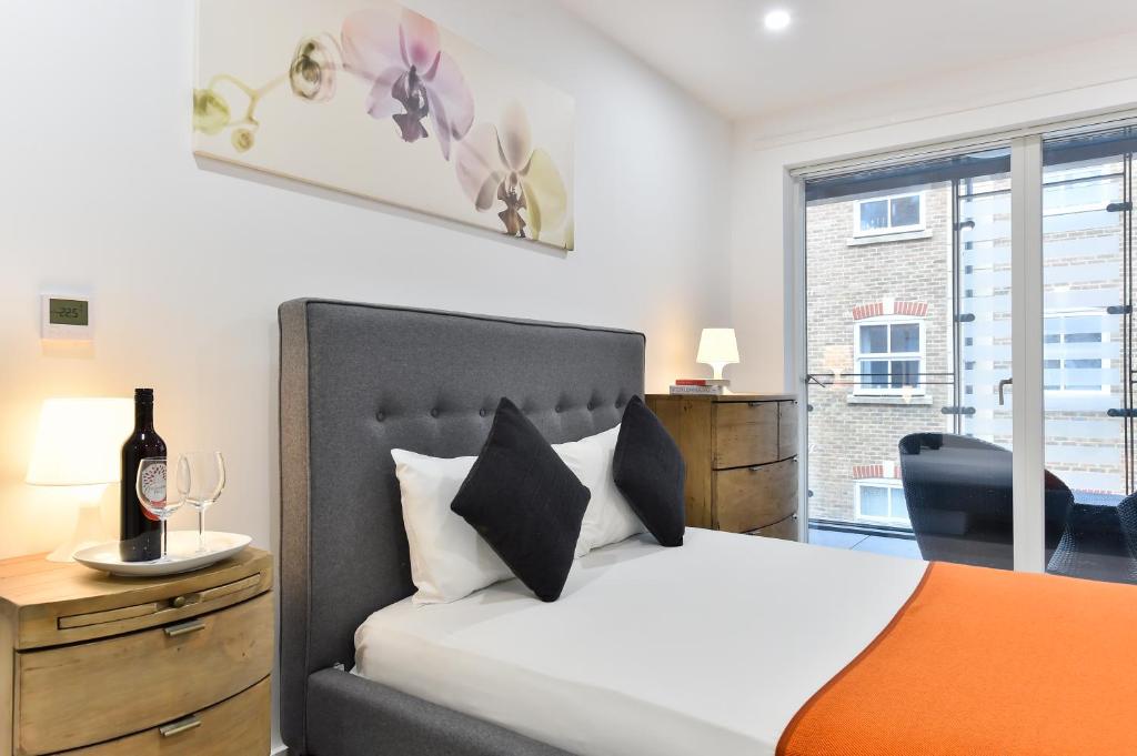 a bedroom with a bed and a desk and a window at Paddington Gardens in London