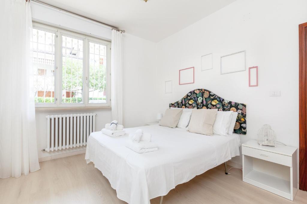 ein weißes Schlafzimmer mit einem weißen Bett und einem Fenster in der Unterkunft [LIDO DI FERMO-FREE PARKING] Appartamento miramare in Lido di Fermo