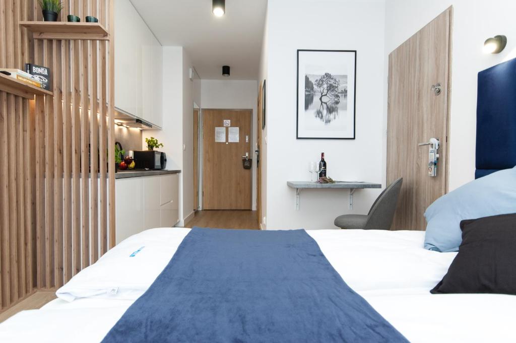 a bedroom with a bed with a blue blanket at Dream Team Industria in Bydgoszcz