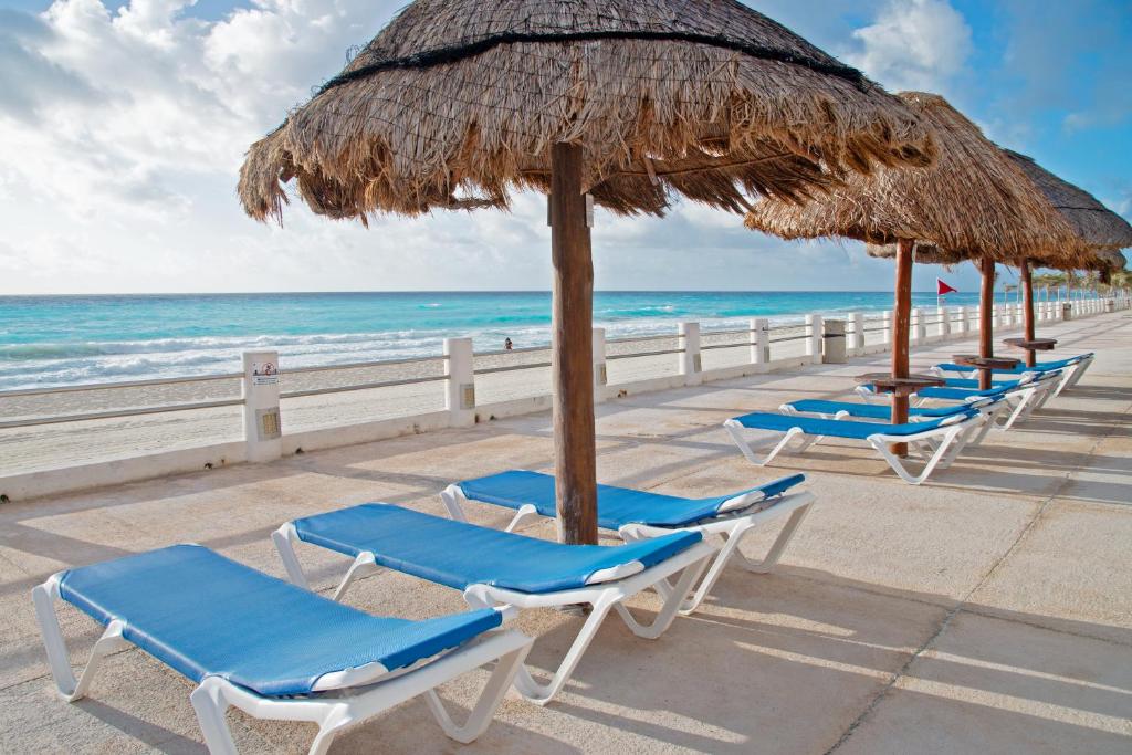 una fila de sillas y sombrillas en una playa en Perfect vacation getaway,Ocean View,Wifi, Beach, en Cancún