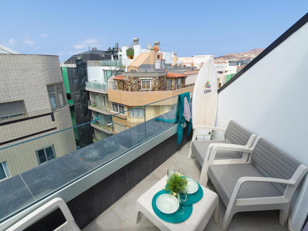 a balcony with a bench and a surfboard on a building at Tusity Yeah Apartments in Las Palmas de Gran Canaria