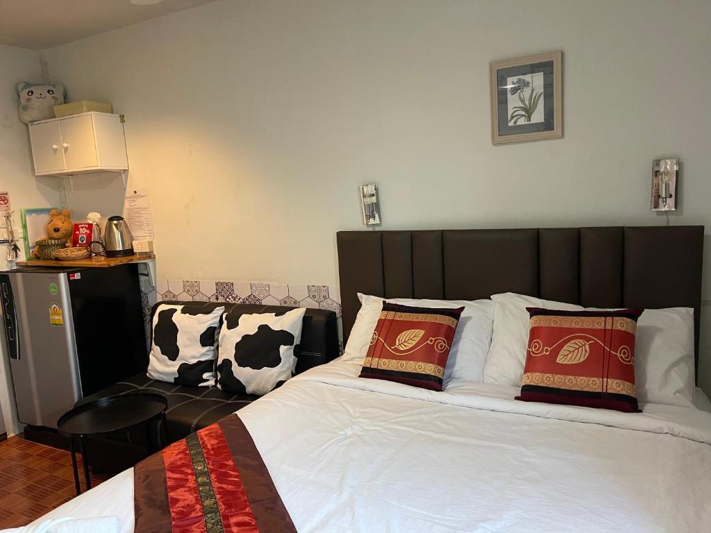 A double bed faces a small sofa and kitchenette-style refreshment area.