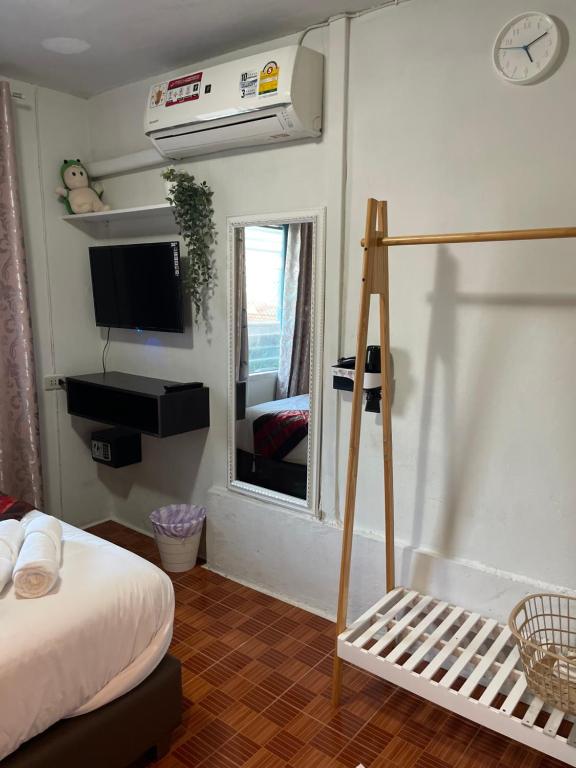 A double bedroom includes air conditioning, a television, mirror and freestanding clothes rack.