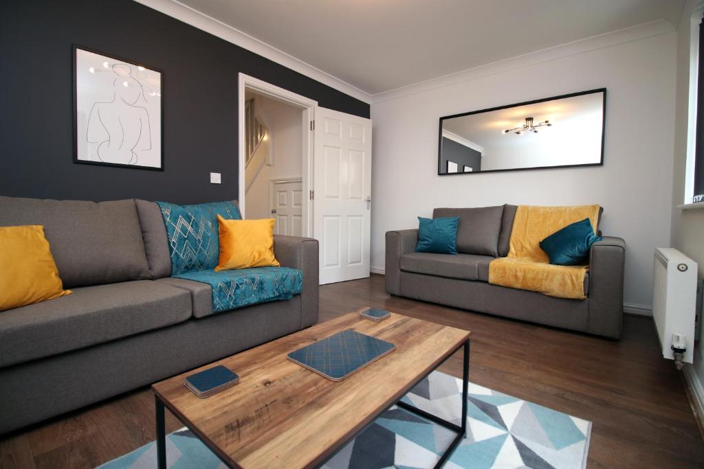 uma sala de estar com um sofá e uma mesa em TRUSCOTT - Spacious Home, High Speed Wi-Fi, Free Parking, Garden, Table Football em Swindon