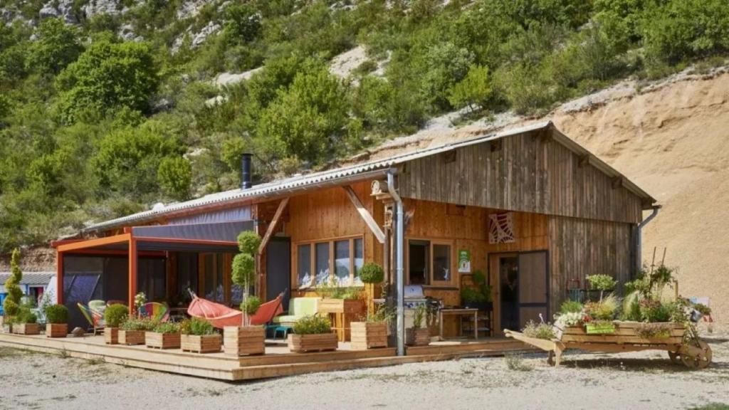 een huis op het strand met stoelen en planten bij La Bella Vista in Curel