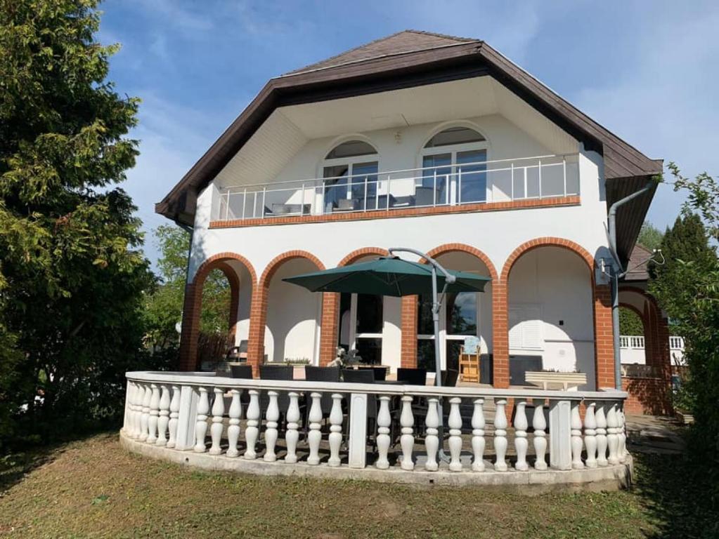 dom z białym płotem przed nim w obiekcie Landhaus Töreki mit Pool w Siófoku