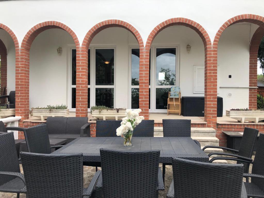 patio ze stołem i wazonem kwiatów w obiekcie Landhaus Töreki mit Pool w Siófoku