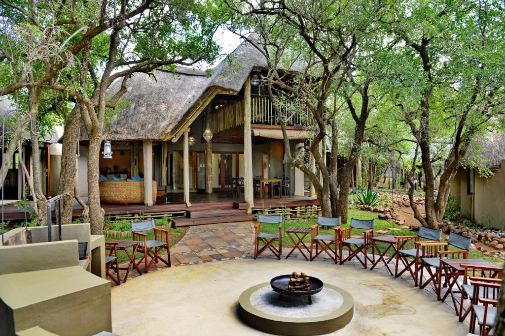 an outdoor patio with chairs and a fountain in front of a house at Tambuti Lodge in Pilanesberg