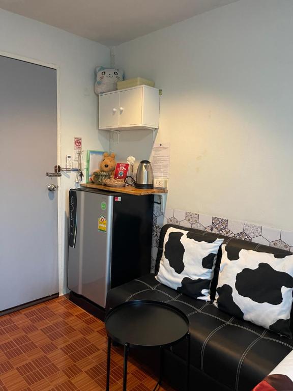 A room entry corner with a sofa, minibar, kettle, and storage cabinet.