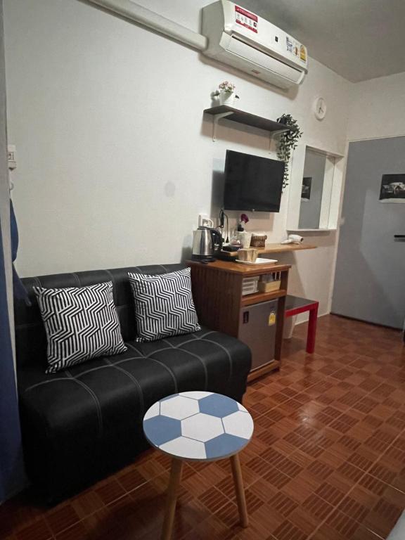 A compact sitting and refreshment area with a sofa, TV, and minibar.