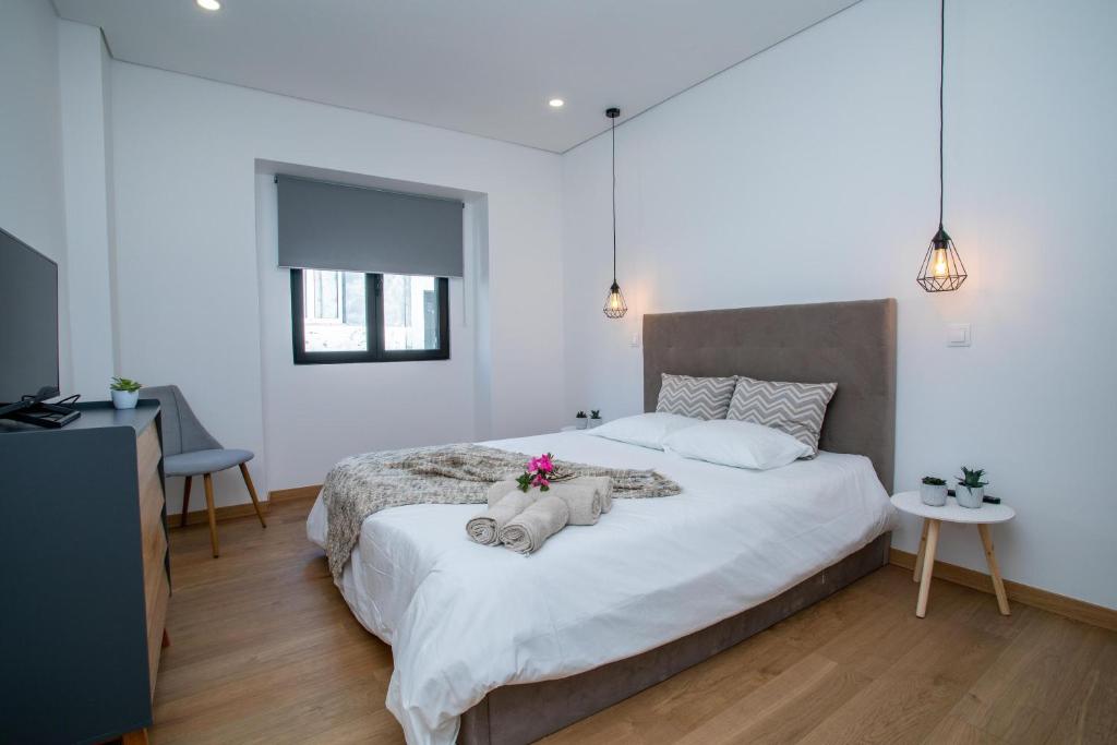 a bedroom with a bed with two stuffed elephants on it at Carvão Pdl Inn in Arrifes