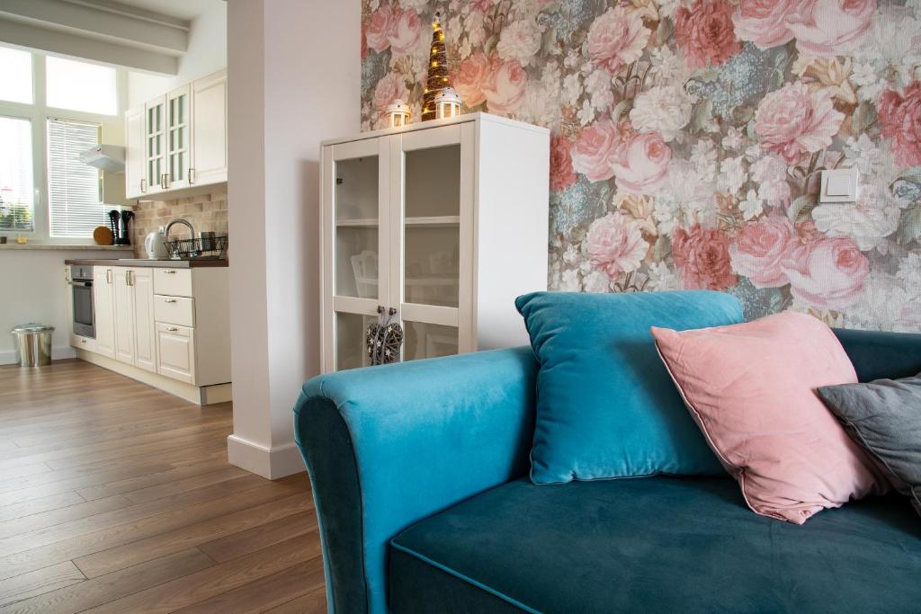 niebieską kanapę w salonie z tapetą kwiatową w obiekcie Apartment Brina w mieście Hum na Sutli