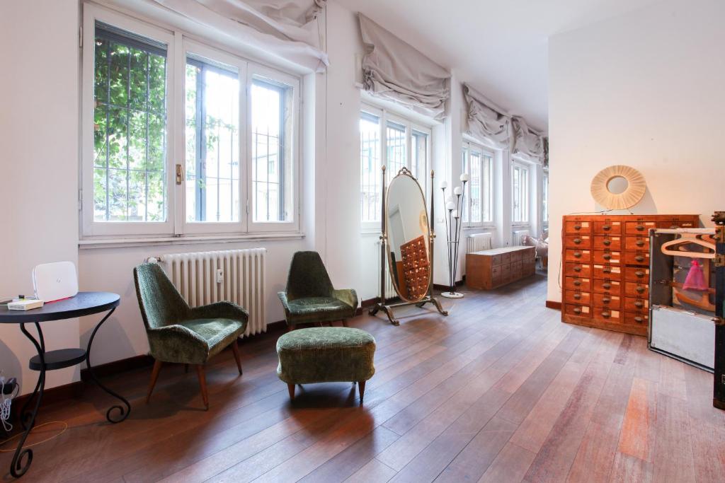 a room with chairs and a table and a mirror at LOVELY MILANO - Beautiful loft with terrace in Porta Romana in Milan